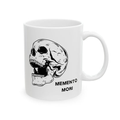  A white ceramic mug with a daring skull design and the words 'Memento Mori' printed on the side.