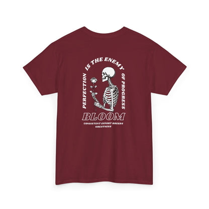 A [red] t-shirt with a central skeleton and rose design and the words “Perfection is the enemy of progress” and “Bloom” on the front.