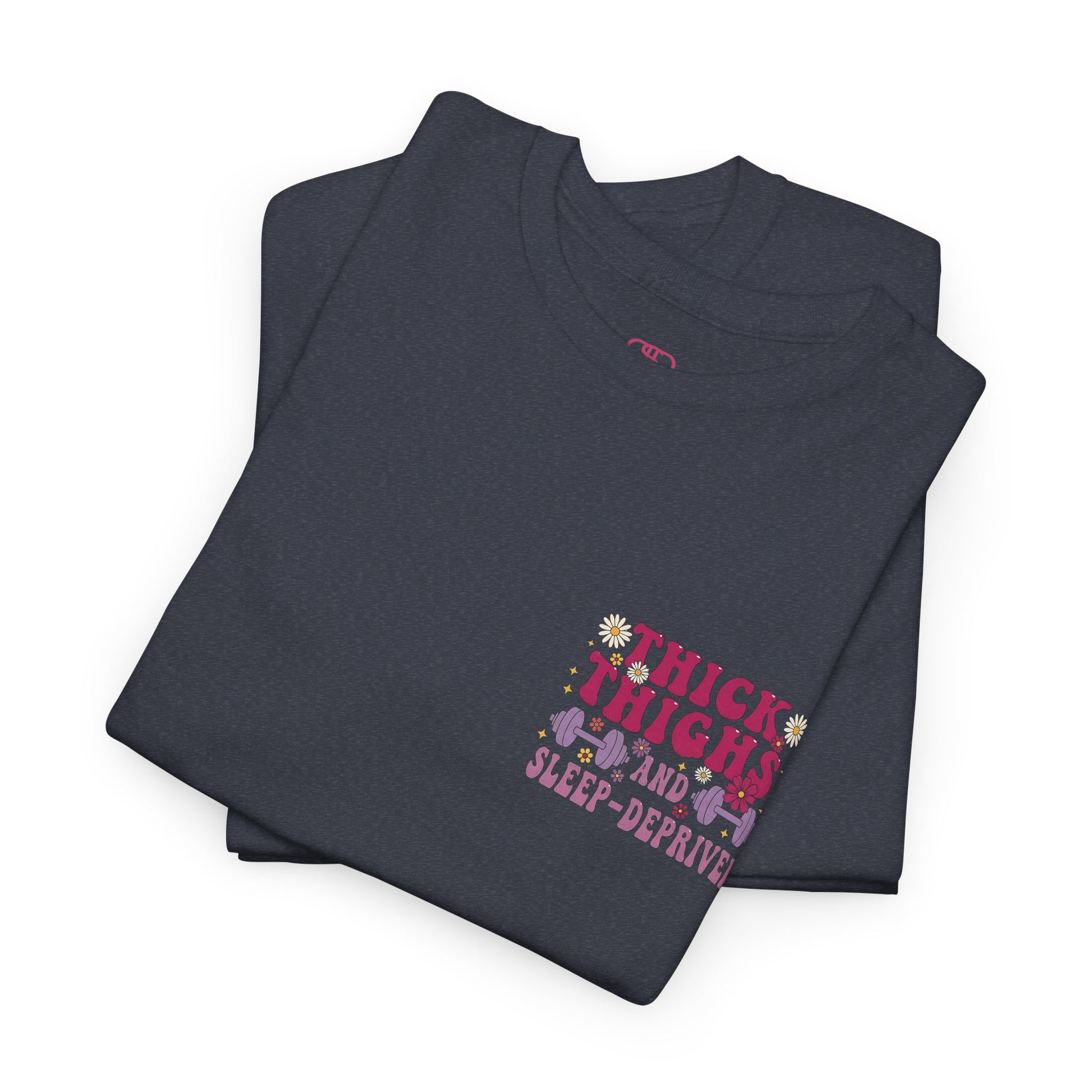 A folded [heather gray] t-shirt with the phrase "Thick Thighs and Sleep Deprived" in a retro font on the front left and enlarged on the back.