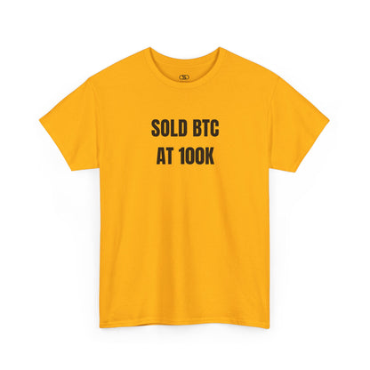 A gold T-shirt with bold text "SOLD BTC At 100K" on the front.