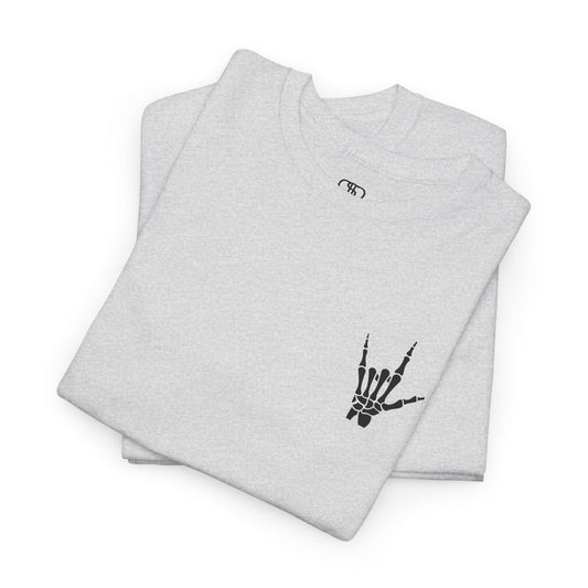 A folded ash gray  t-shirt with small rock hand symbol on front, and "Rules.. Never Heard of Them" graffiti text on the back.