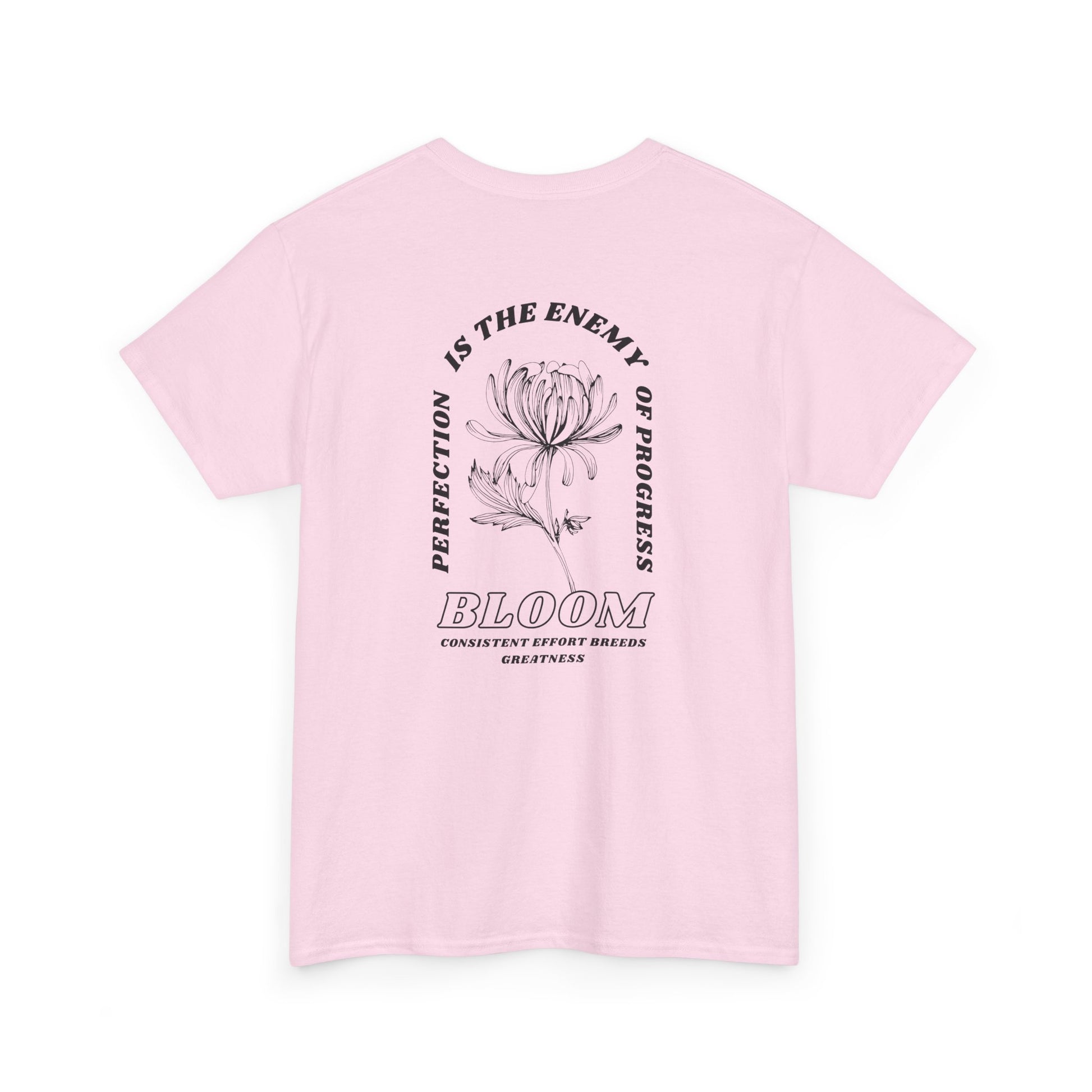 A [light pink] t-shirt with a central flower design and the words “Perfection is the enemy of progress” and “Bloom” underneath it the phrase "Consistent effort breeds greatness," featured on the back of the t-shirt.