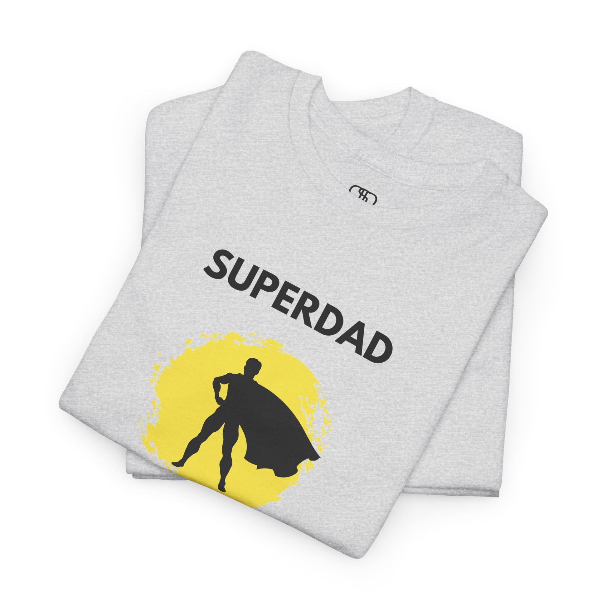 A folded ash gray T-shirt with a "Superdad" text and a silhouette of a person with a cape on a yellow circle background.