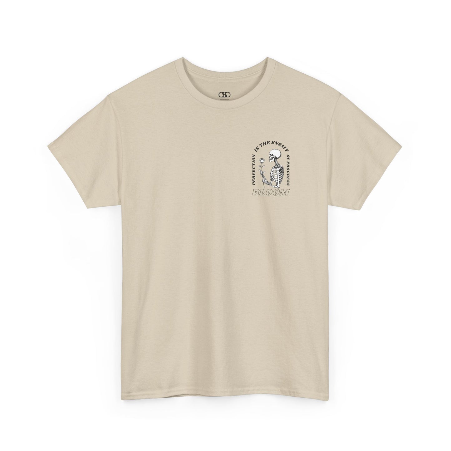A [sand] t-shirt with a central skeleton and rose design and the words “Perfection is the enemy of progress” and “Bloom” on the front.