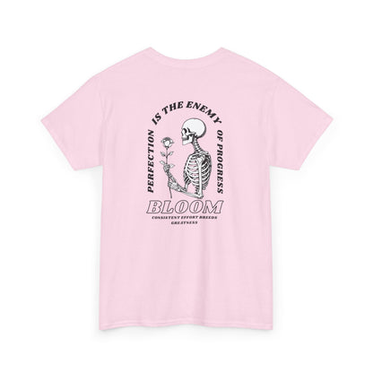 A [light pink] t-shirt with a central skeleton and rose design and the words “Perfection is the enemy of progress” and “Bloom” on the front.