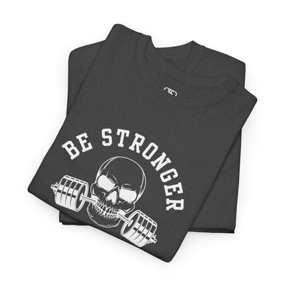  A folded t-shirt in [heather gray] with a skull biting a barbell and the words “Be Stronger Than Your Excuses.”