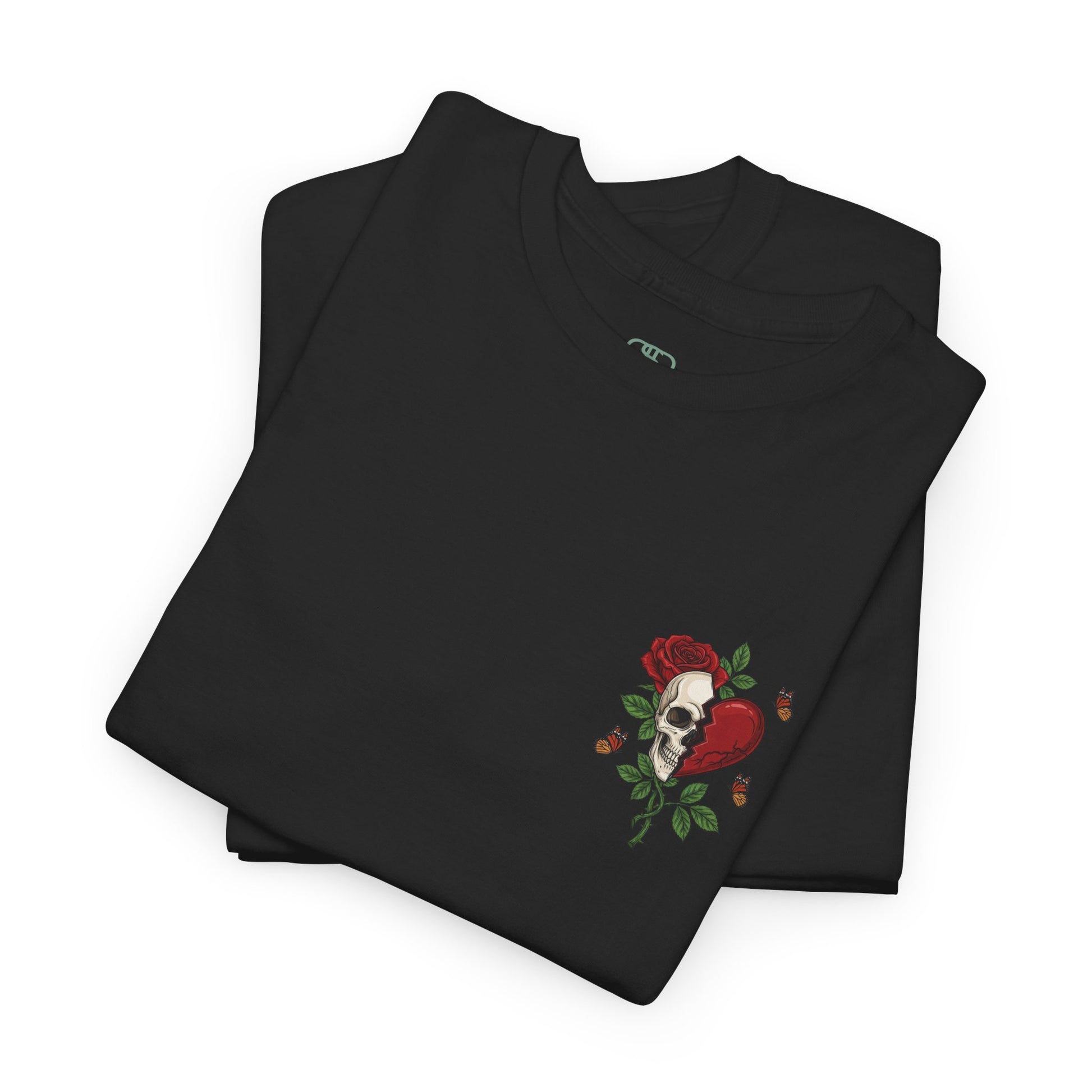 A folded black t-shirt with a front design of a half skull, half broken heart, and a rose. The back reads "Gym Heals" in red.