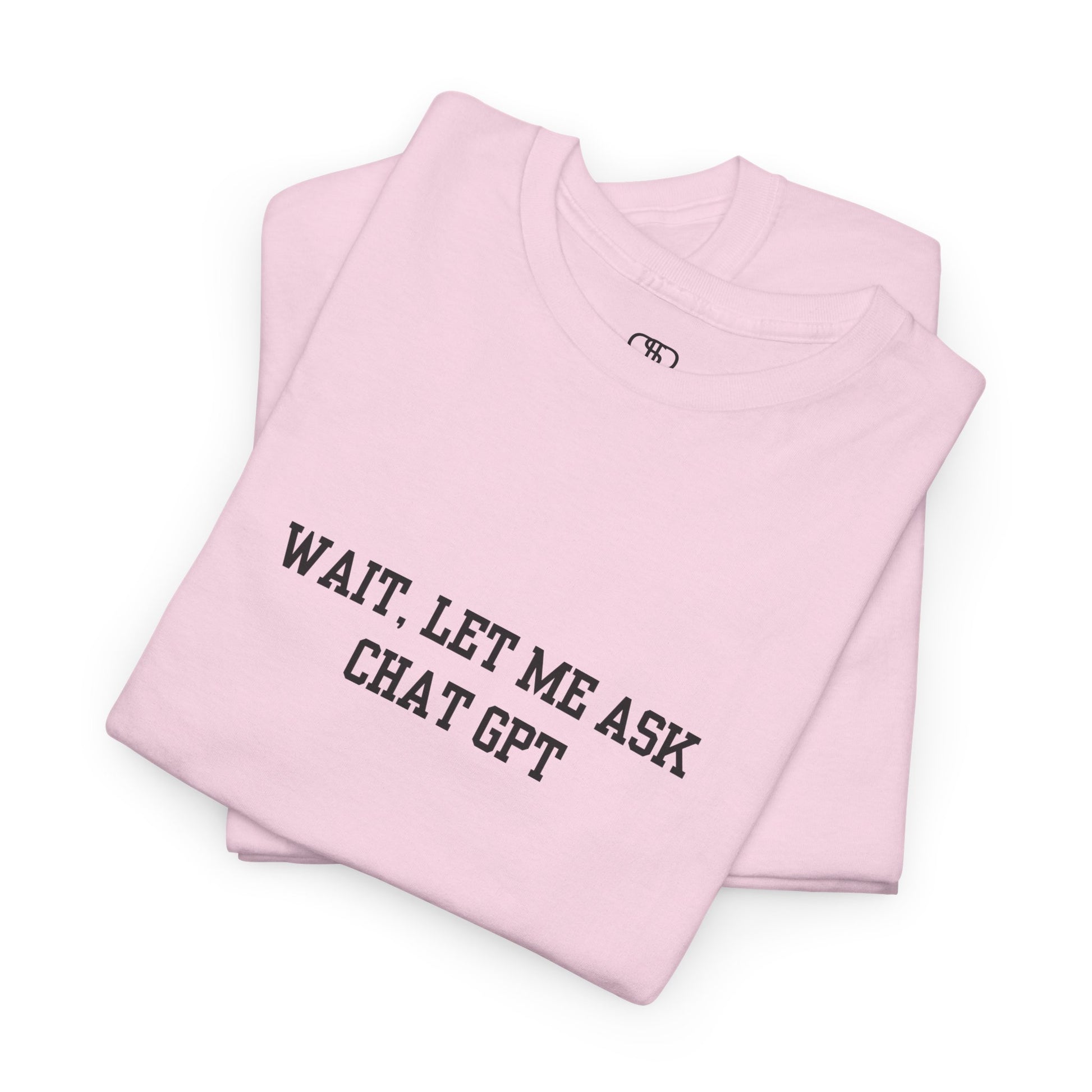 A [folded light pink] t-shirt with the phrase “Wait, Let me ask Chat Gpt.” on the front.