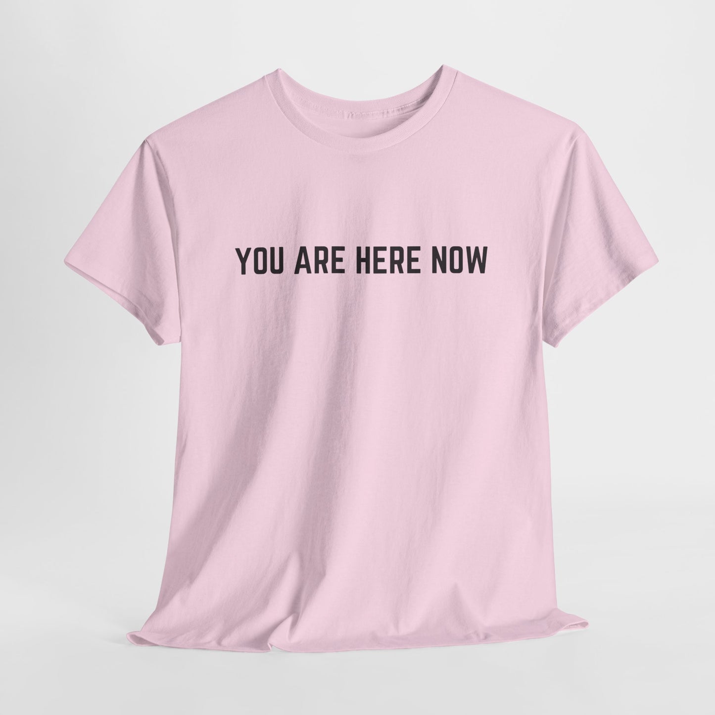 Front of a t-shirt with the grounding phrase "You are Here now" in a clean, minimalist font.