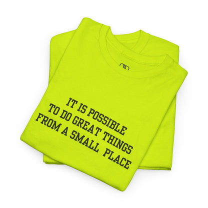 A folded safety green t-shirt with the quote “It is possible to do great things from a small place” on the front.
