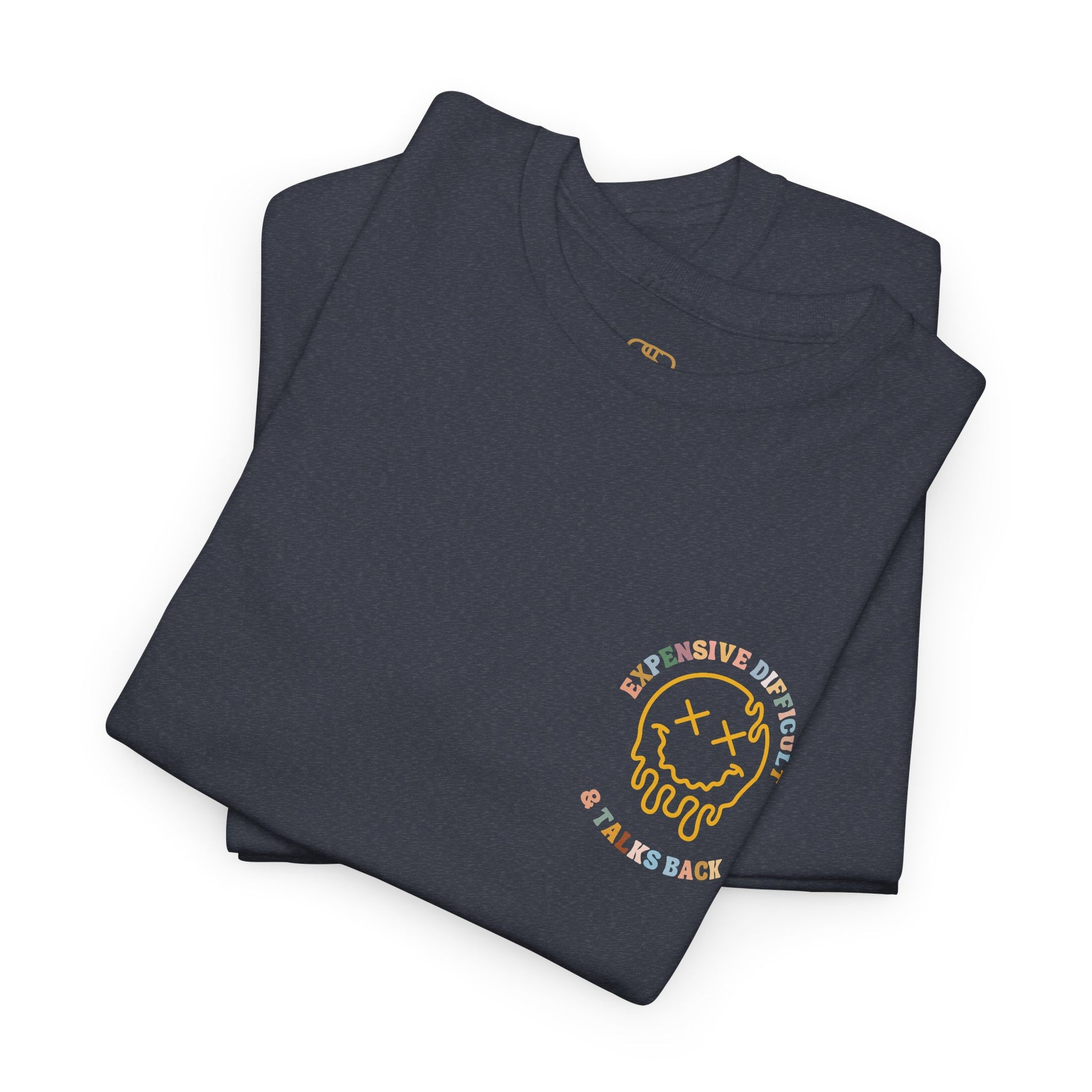 A folded heather gray t-shirt with a melting emoji and the words “Expensive Difficult & Talks Back” on the front and the full phrase in a retro wavy font on the back.