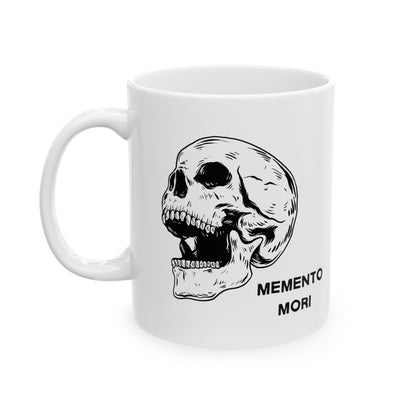  A white ceramic mug with a daring skull design and the words 'Memento Mori' printed on the side.
