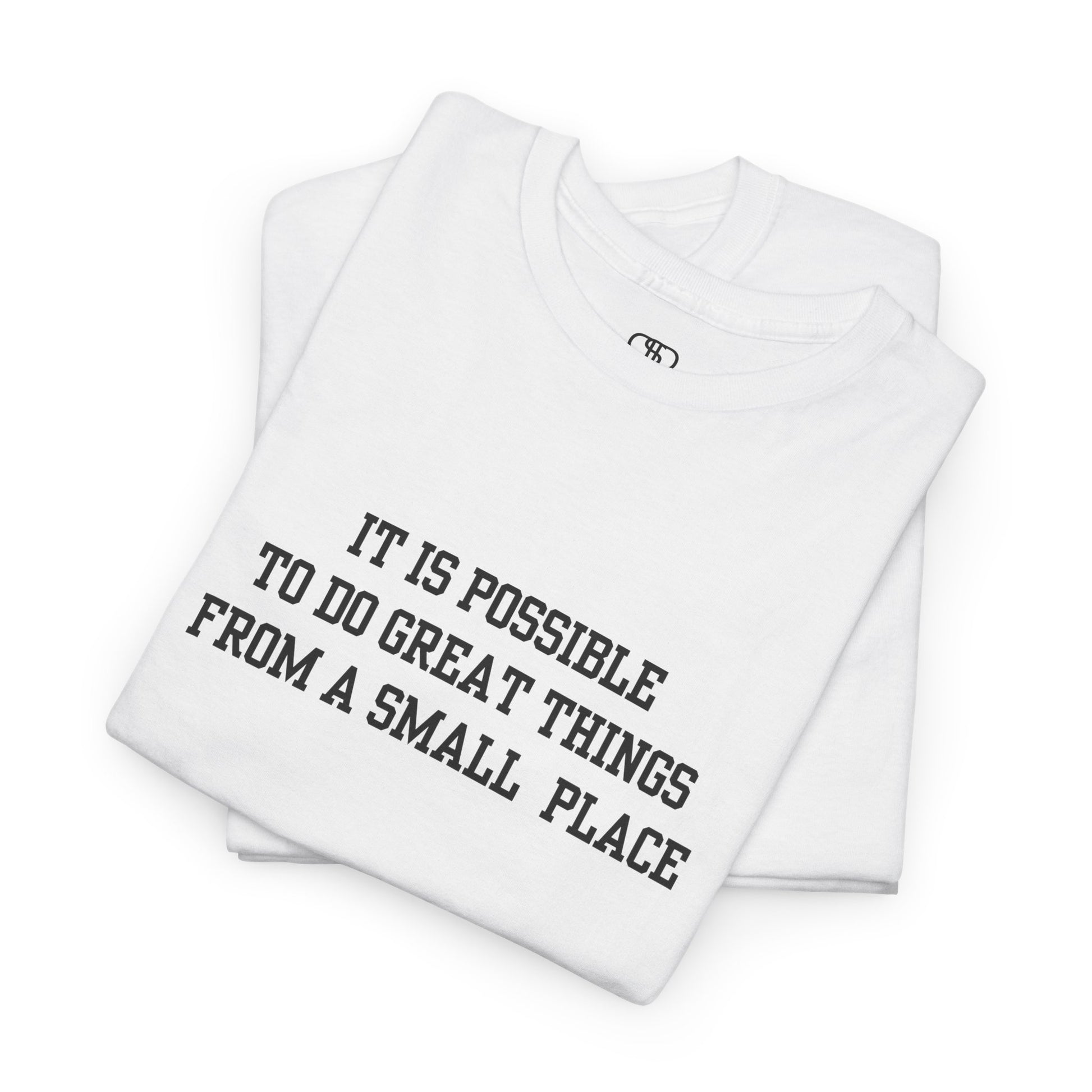 A folded white t-shirt with the quote “It is possible to do great things from a small place” on the front.
