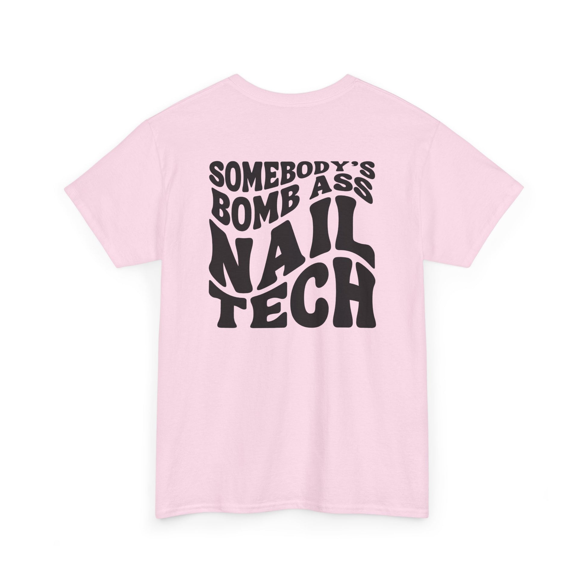 A light pink t-shirt with black text 'SOMEBODY'S BOMB ASS NAIL TECH' on a white background in a creative wavy font. 