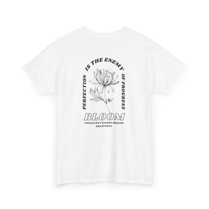 A [white] t-shirt with a central flower design and the words “Perfection is the enemy of progress” and “Bloom” underneath it the phrase "Consistent effort breeds greatness." 