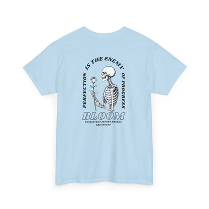 A [light blue] t-shirt with a central skeleton and rose design and the words “Perfection is the enemy of progress” and “Bloom” on the front.