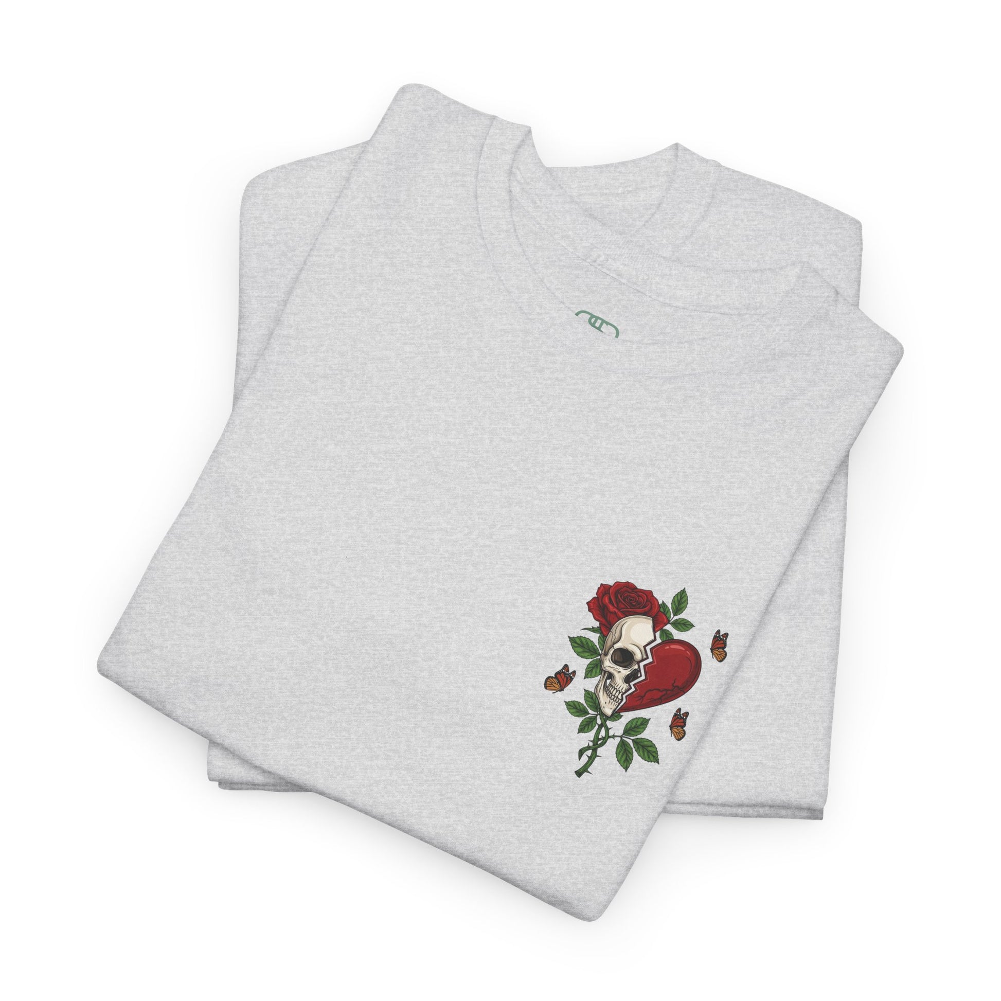A folded ash gray t-shirt with a front design of a half skull, half broken heart, and a rose. The back reads "Gym Heals" in red.