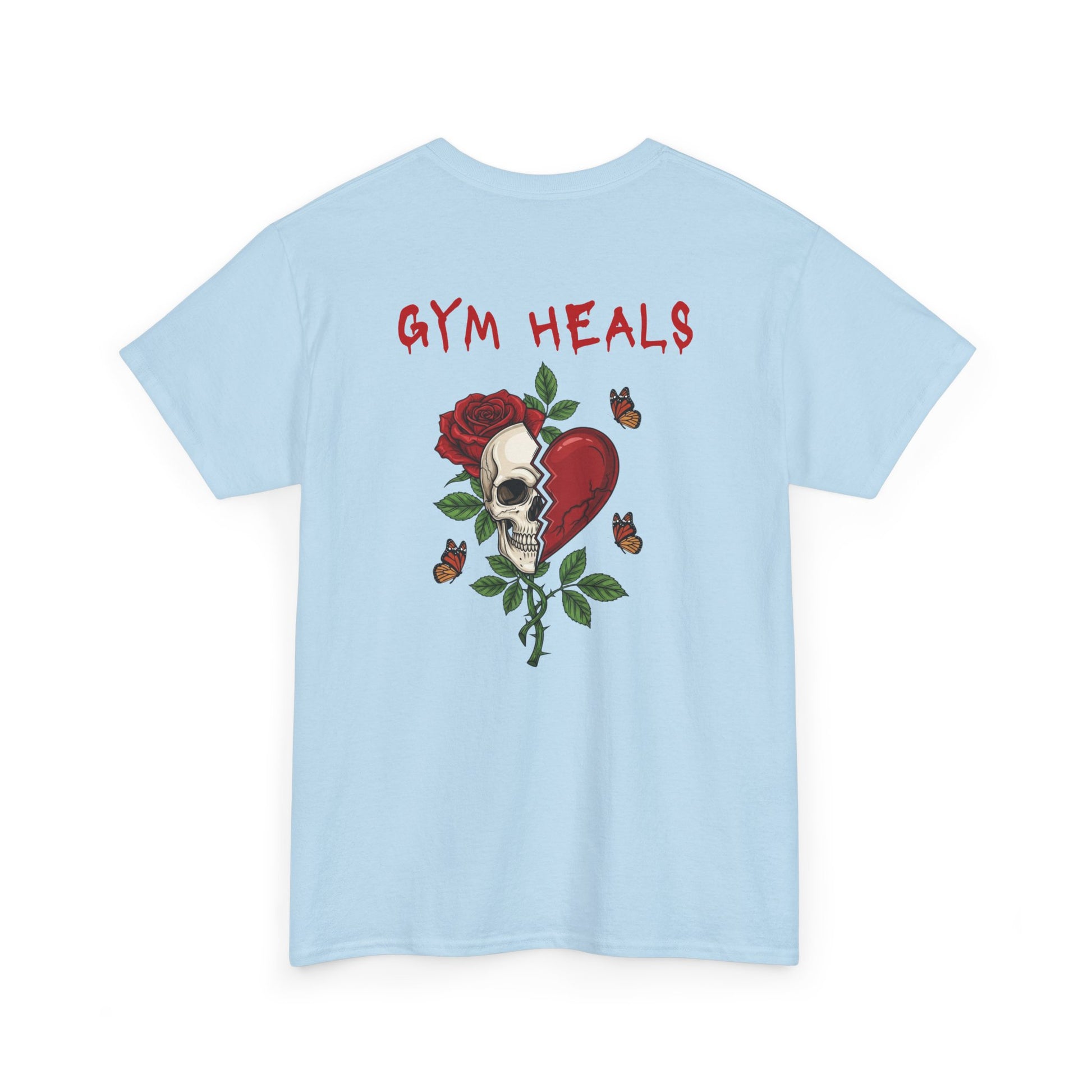 A light blue t-shirt with a front design of a half skull, half broken heart, and a rose. The back reads "Gym Heals" in red.