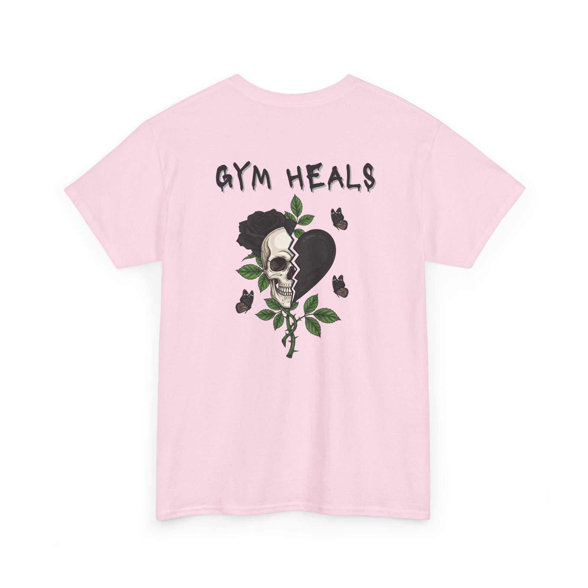 A light pink t-shirt with a front design of a half skull, half broken heart, and a rose. The back reads "Gym Heals" in black.