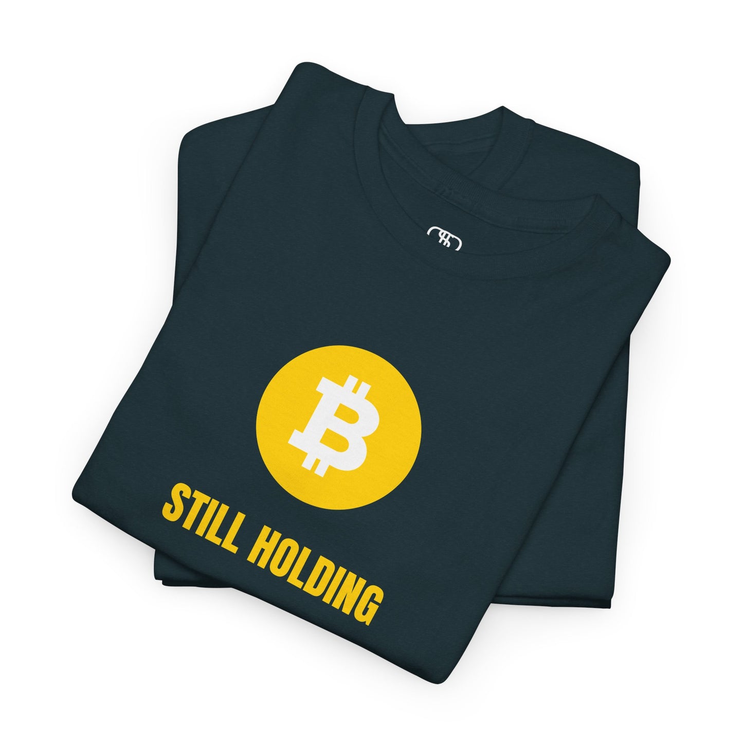 A folded t-shirt with Bitcoin symbol and 'STILL HOLDING' text on a white background