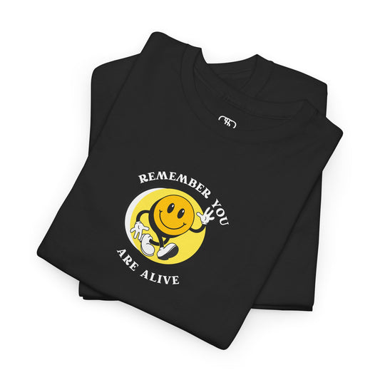 Folded Black Front of a Black t-shirt showing a smiling waving emoji with curved text "Remember You Are Alive." The back shows a vibrant, smiling sunflower with the words "Make the Best Out of Everyday."