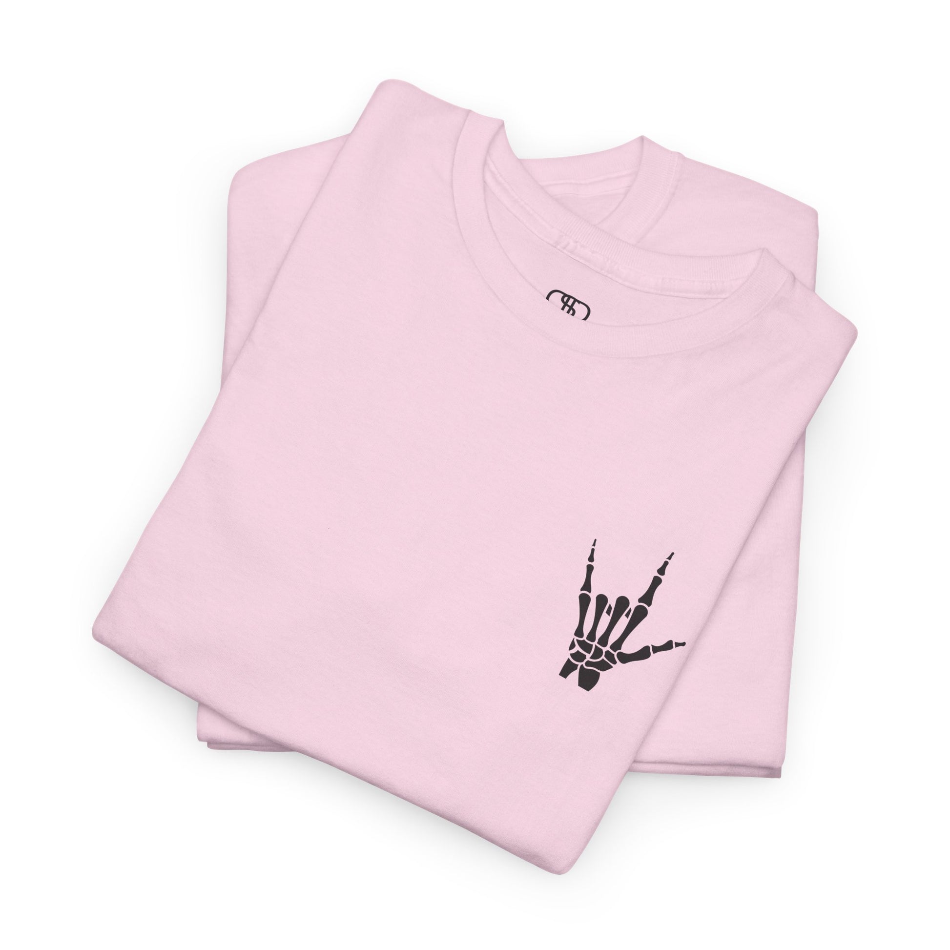 A folded light pink t-shirt with small rock hand symbol on front, and "Rules.. Never Heard of Them" graffiti text on the back.