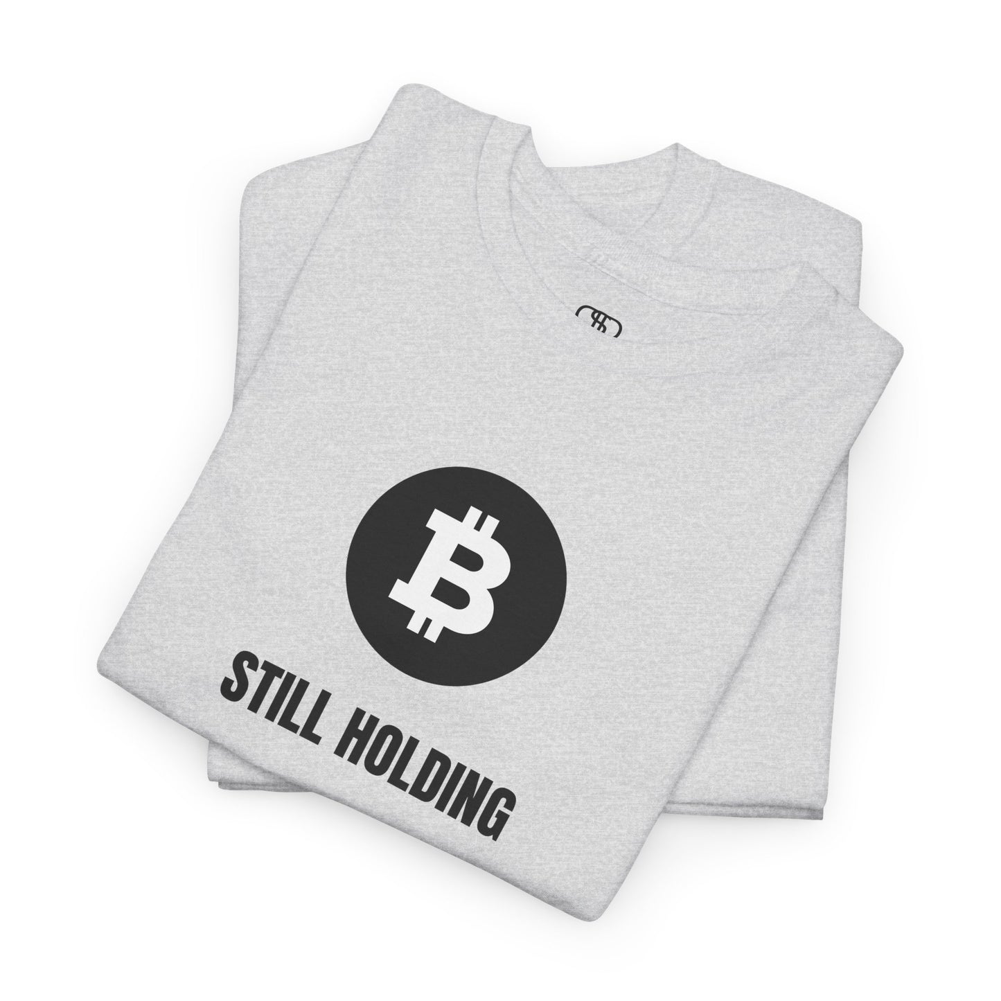 A Folded ash T-shirt with a Bitcoin emblem and "Still Holding" text in black.