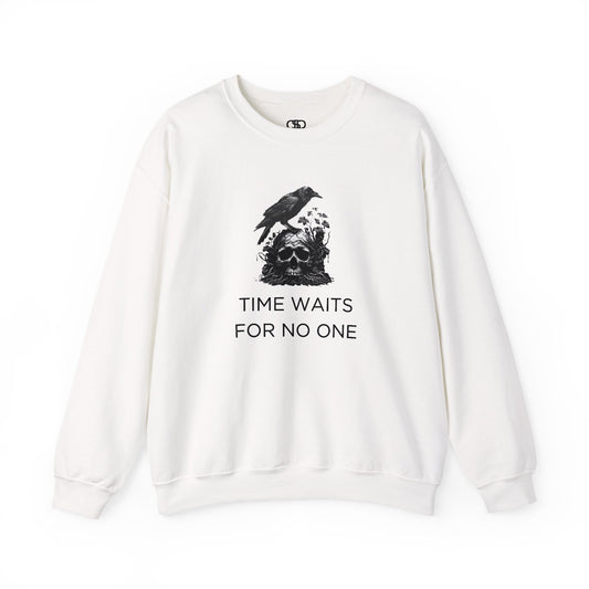 A sweatshirt featuring a detailed illustration of a crow perched on a human skull that is intertwined with overgrown vines and moss. Along with the words Time Waits For No One. 