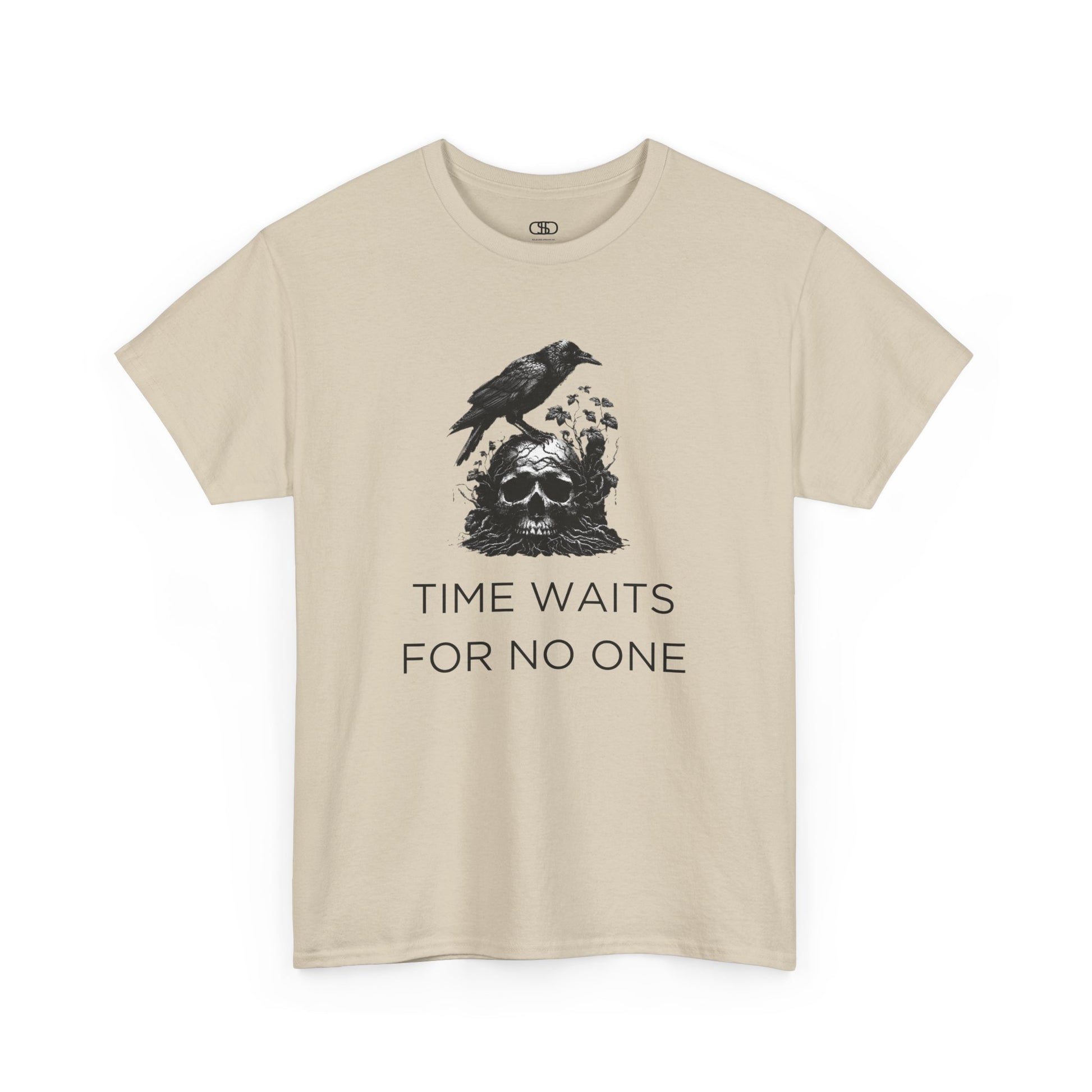 A close-up of a t-shirt with a gothic illustration. A black crow stands atop a weathered skull, which has moss and delicate vines growing through its eye sockets and around its form, blending nature and death.