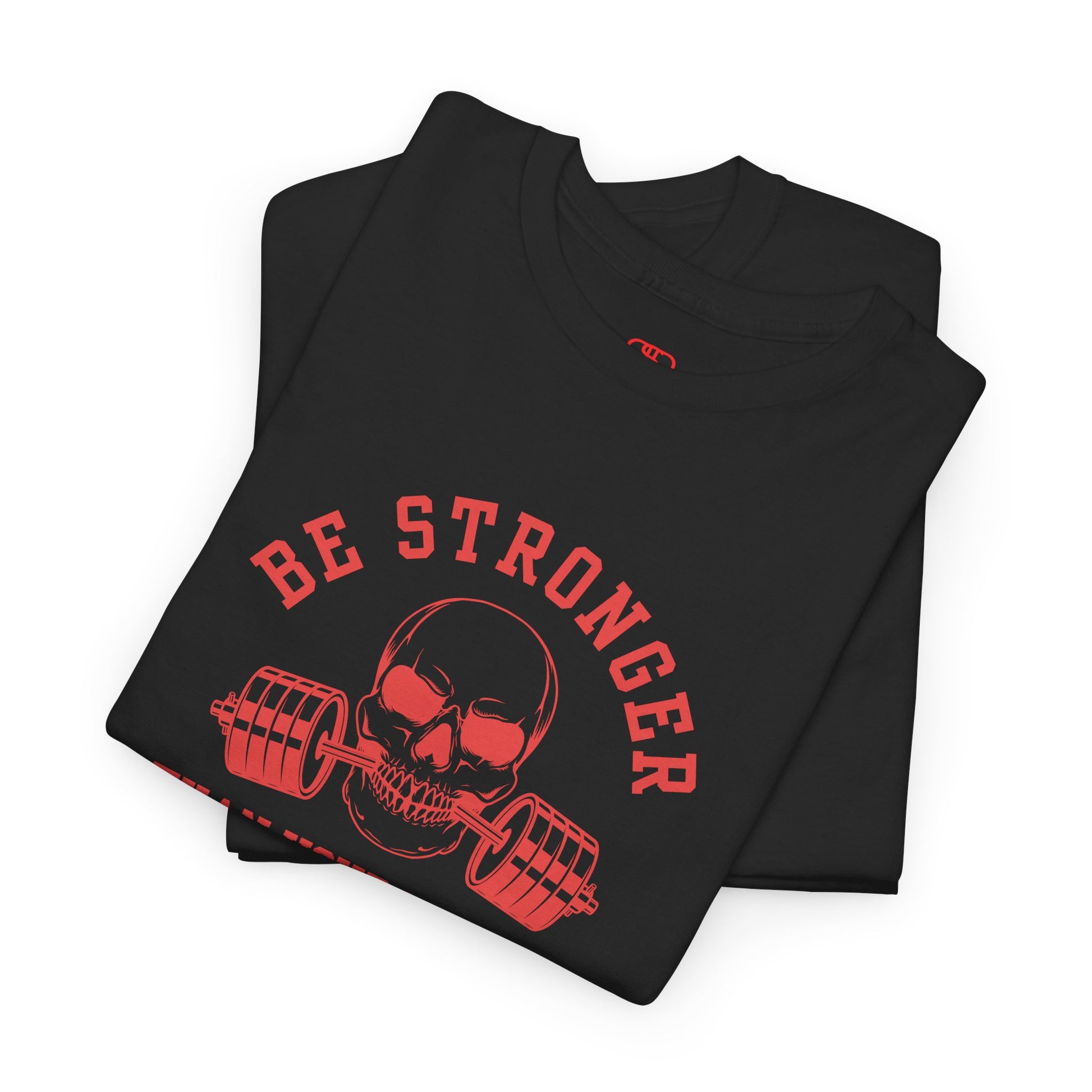 A folded t-shirt in [black] with a skull biting a barbell and the words “Be Stronger Than Your Excuses.”