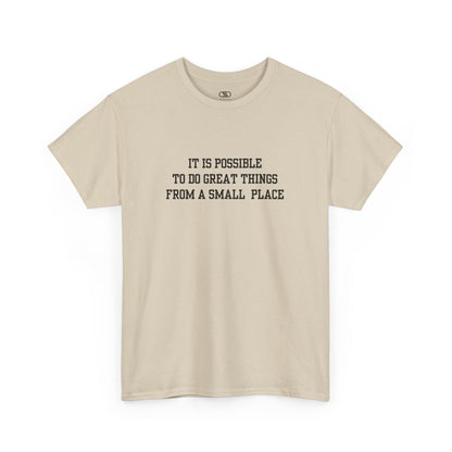 A sand t-shirt with the quote “It is possible to do great things from a small place” on the front.