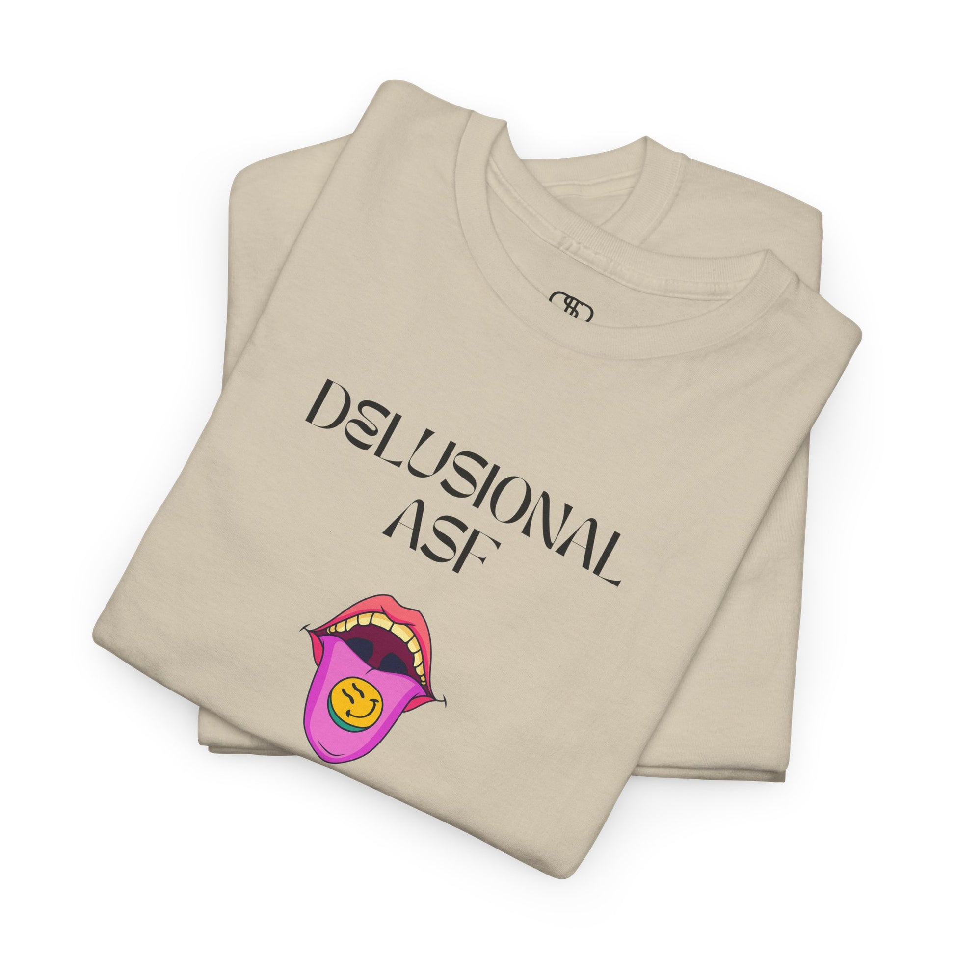 A folded sand T-shirt with "Delusional asf" text, an open mouth graphic with tongue out, and a happy face emoji pill.