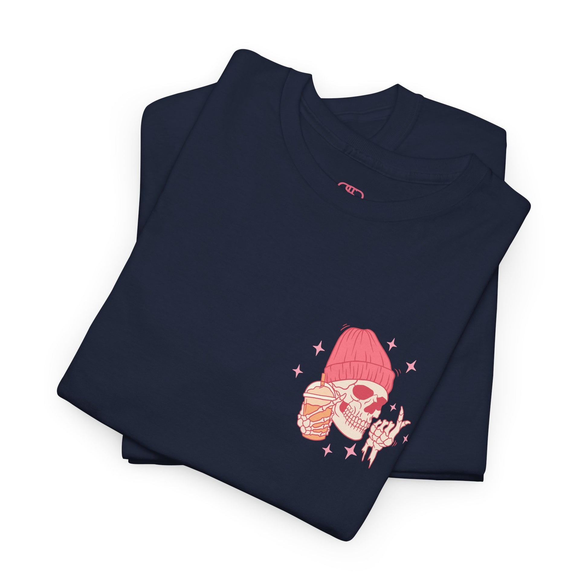 A NAVY FOLDED T-shirt with a skeleton in a pink beanie holding a frozen coffee, snapping fingers, surrounded by sparkles graphic.