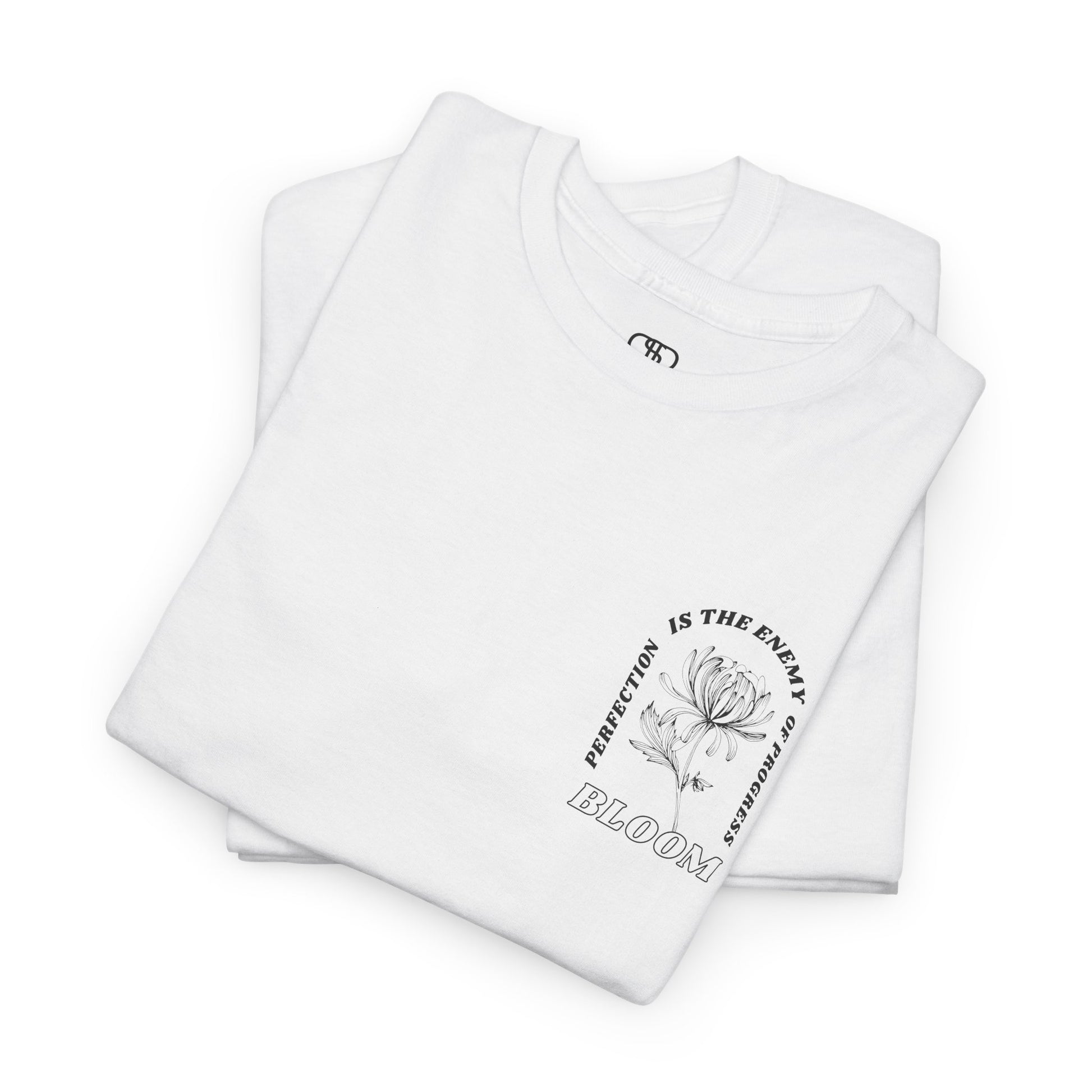 A [folded white] t-shirt with a central flower design and the words “Perfection is the enemy of progress” and “Bloom” underneath it the phrase "Consistent effort breeds greatness," featured on the back of the t-shirt.