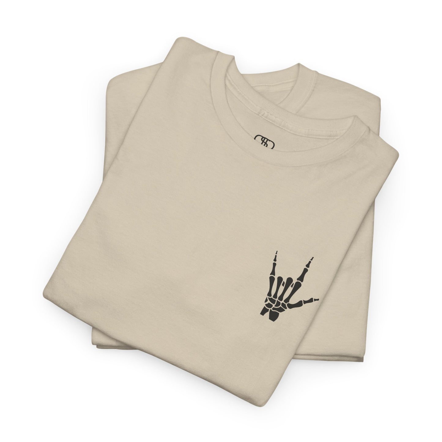 A folded sand t-shirt with small rock hand symbol on front, and "Rules.. Never Heard of Them" graffiti text on the back.