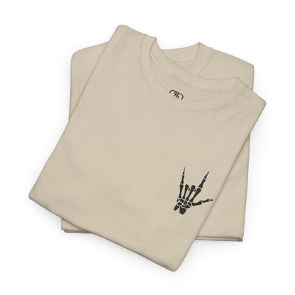 A folded sand t-shirt with small rock hand symbol on front, and "Rules.. Never Heard of Them" graffiti text on the back.