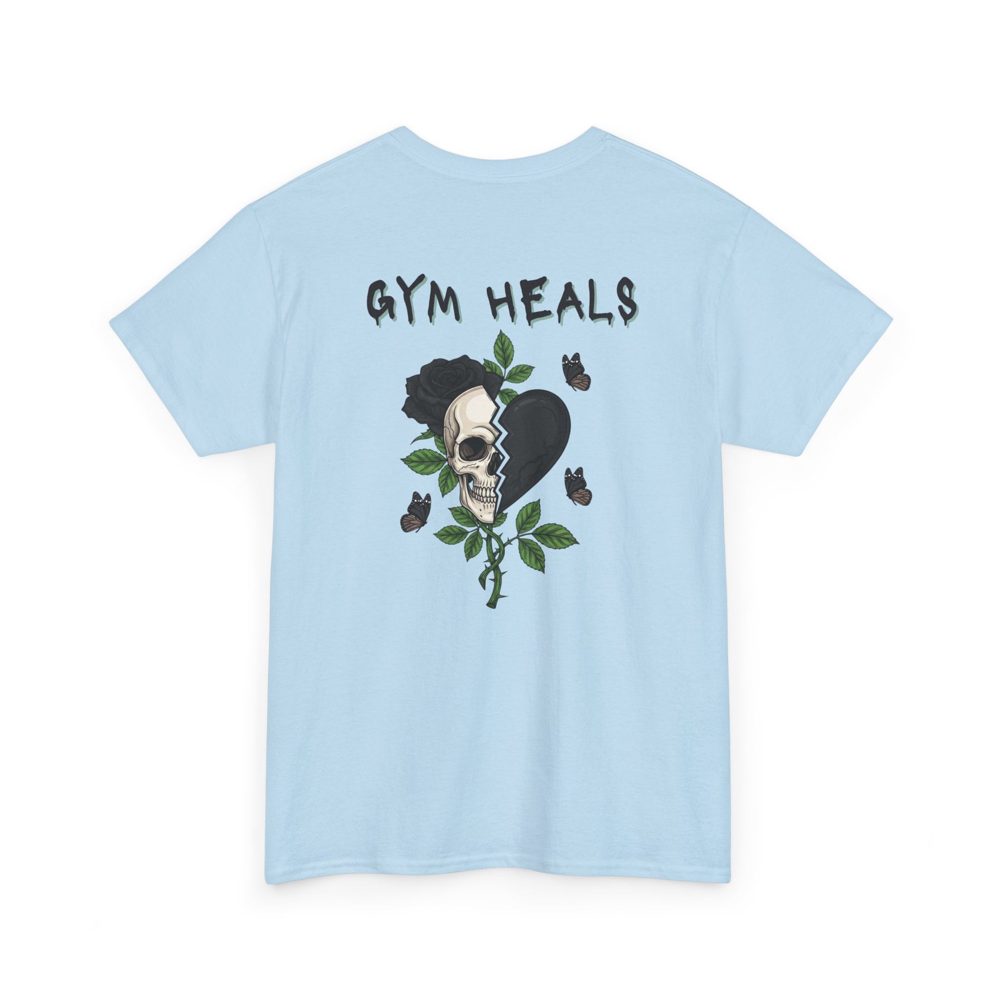 A light blue t-shirt with a front design of a half skull, half broken heart, and a rose. The back reads "Gym Heals" in black.