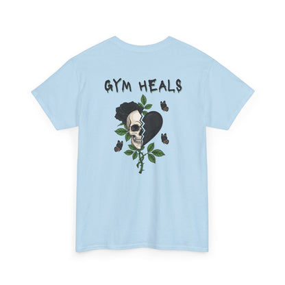 A light blue t-shirt with a front design of a half skull, half broken heart, and a rose. The back reads "Gym Heals" in black.