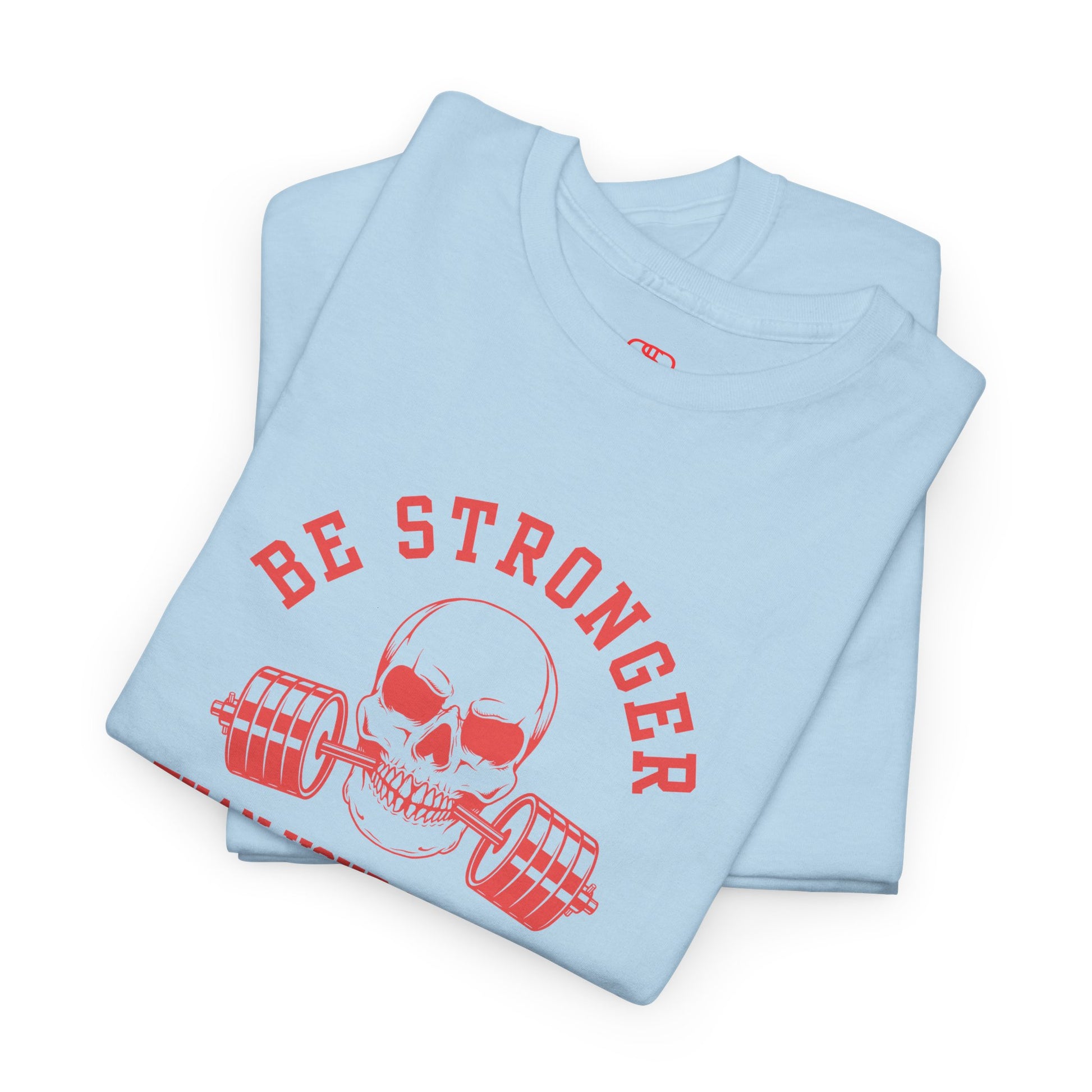 A t-shirt in [folded light blue] with a skull biting a barbell and the words “Be Stronger Than Your Excuses.”