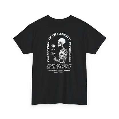 A [black] t-shirt with a central skeleton and rose design and the words “Perfection is the enemy of progress” and “Bloom” on the front.