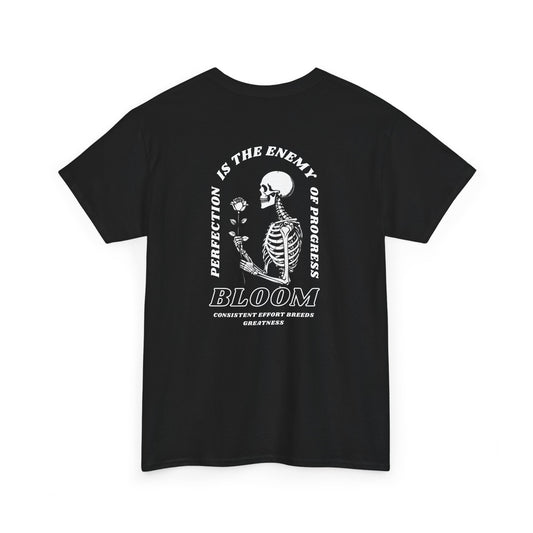 A [black] t-shirt with a central skeleton and rose design and the words “Perfection is the enemy of progress” and “Bloom” on the front.