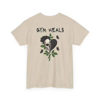 A t-shirt with a front design of a half skull, half broken heart, and a rose. The back reads "Gym Heals" in black.