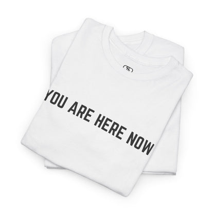 Front of a t-shirt with the grounding phrase "You are Here now" in a clean, minimalist font.