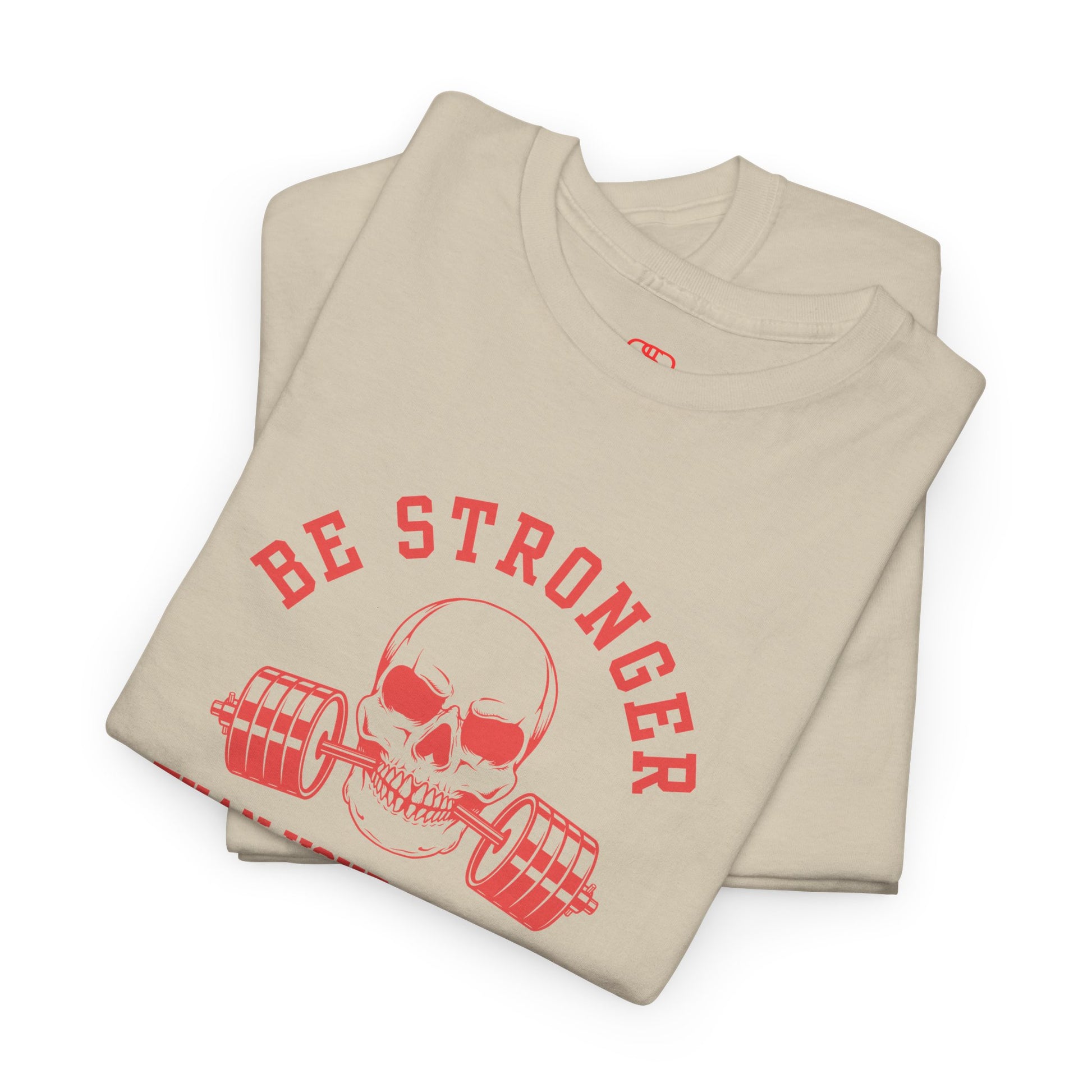 A t-shirt in [folded sand] with a skull biting a barbell and the words “Be Stronger Than Your Excuses.”