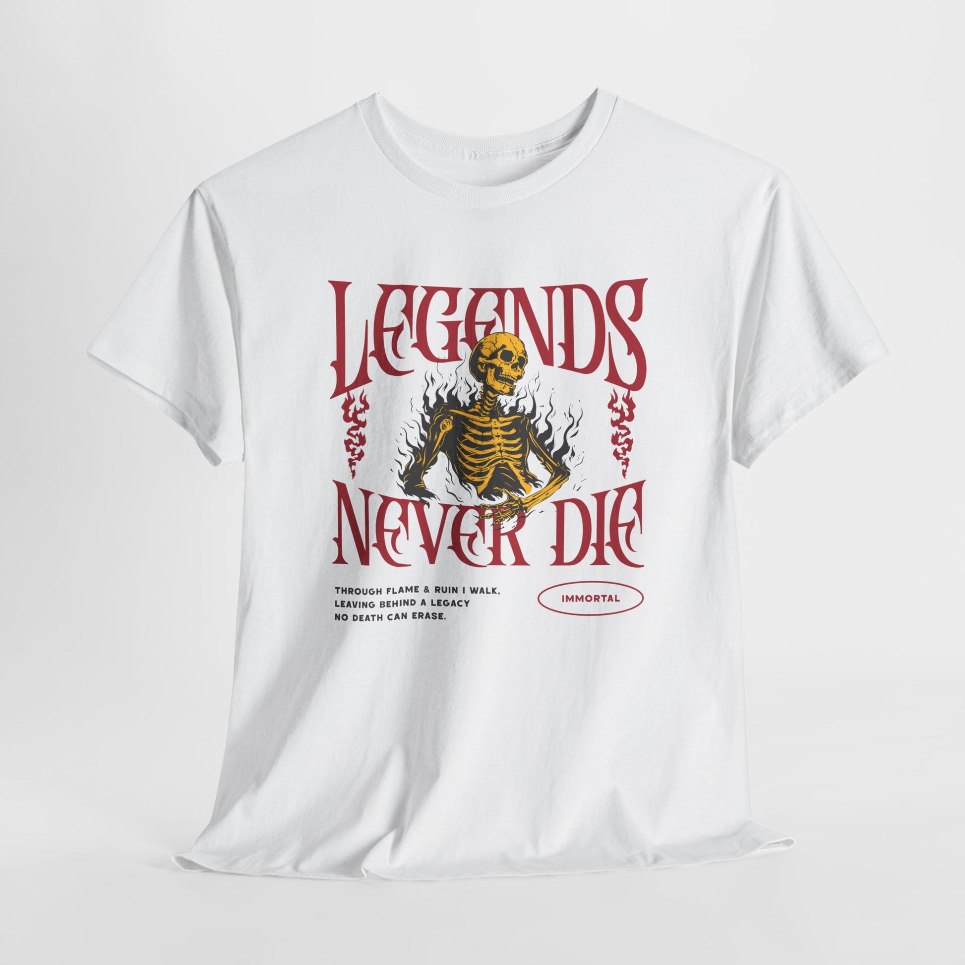A white t-shirt with a graphic of a defiant skeleton engulfed in flames. The words “Legends Never Die” are prominently displayed, with a smaller quote and the word “Immortal” included in the design.