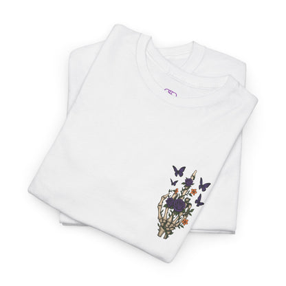 A folded white t-shirt with a skeleton hand flipping its middle finger on the front surrounded by vines, roses, & butterflies, and a full skeleton design on the back with the phrase “My Last Flying Fuck.”