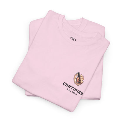 A folded light pink t-shirt with a hand graphic design holding nail polish with polished nails followed by the words Certified Nail Tech beneath it.