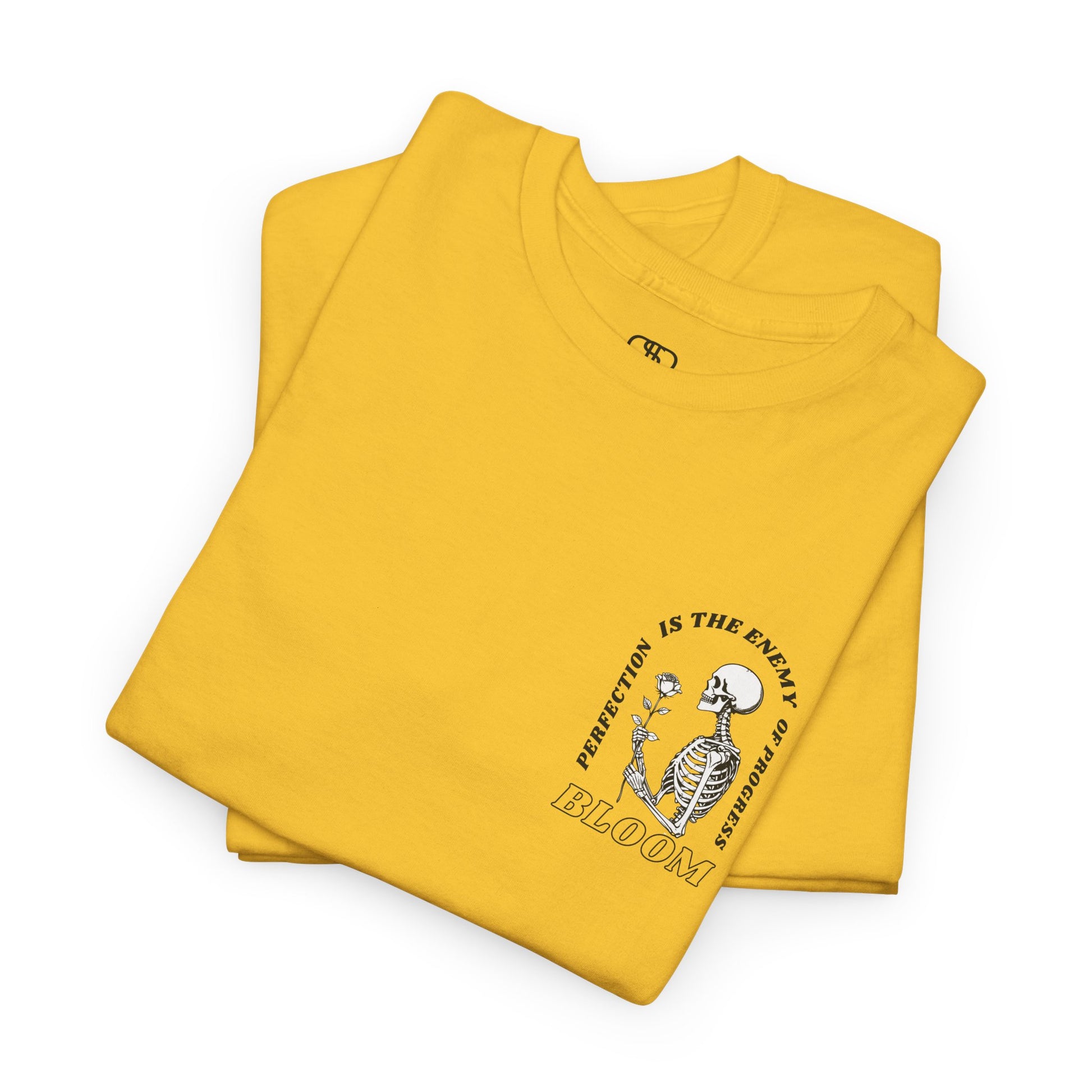 A [folded daisy] t-shirt with a central skeleton and rose design and the words “Perfection is the enemy of progress” and “Bloom” on the front.