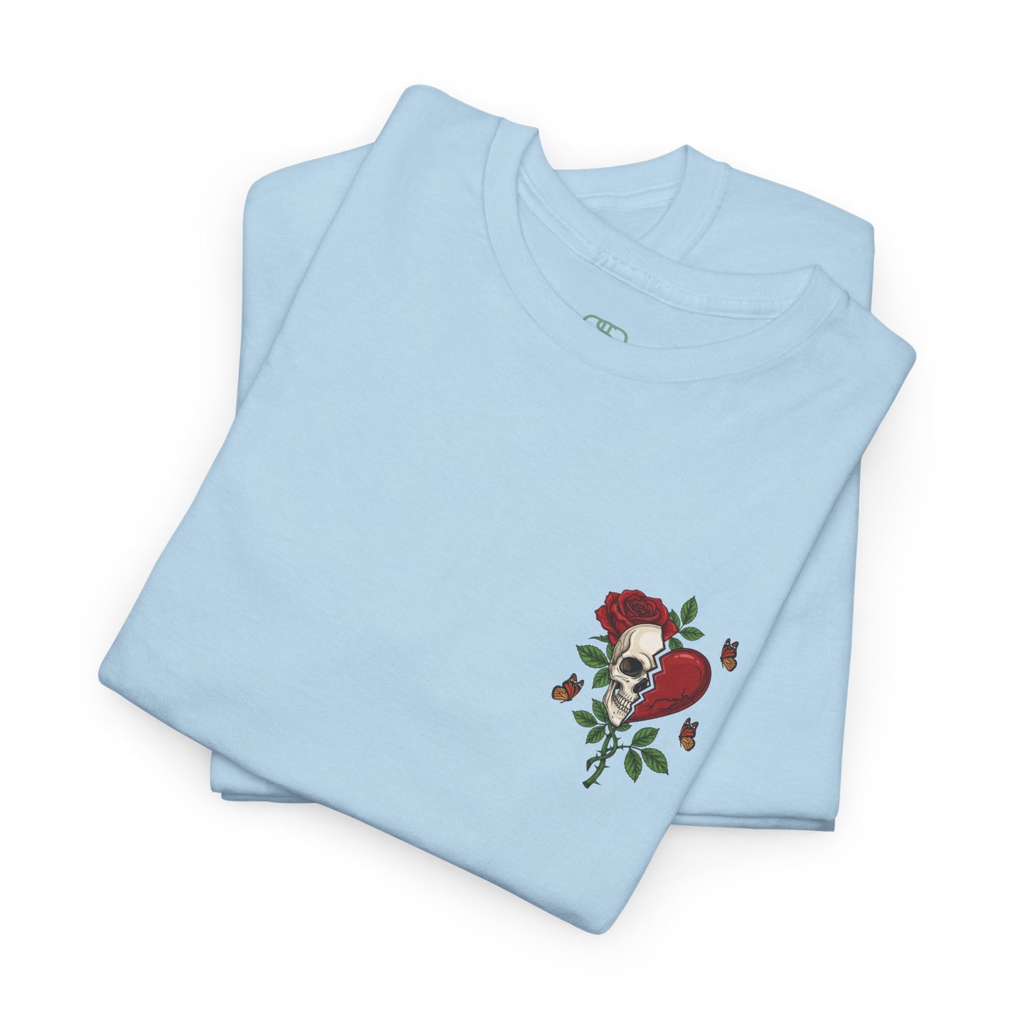 A folded light blue t-shirt with a front design of a half skull, half broken heart, and a rose. The back reads "Gym Heals" in red.