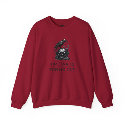 A sweatshirt featuring a detailed illustration of a crow perched on a human skull that is intertwined with overgrown vines and moss. Along with the words Time Waits For No One. 